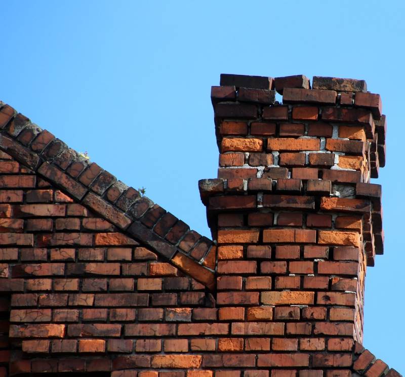 Damaged chimney on an Placentia home showing cracks and missing mortar